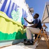 Francis M. Mitalo, with UCR's Office of Sustainability, helps paint the "smog-eating" mural on Tuesday, Oct. 3, 2023. (UCR/Stan Lim)
