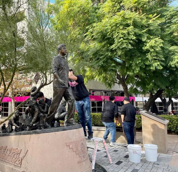 students cleaning statue