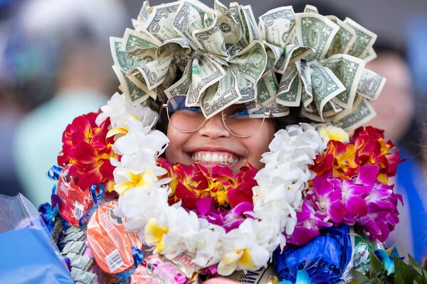 Graduate covered in floral leis and money crown