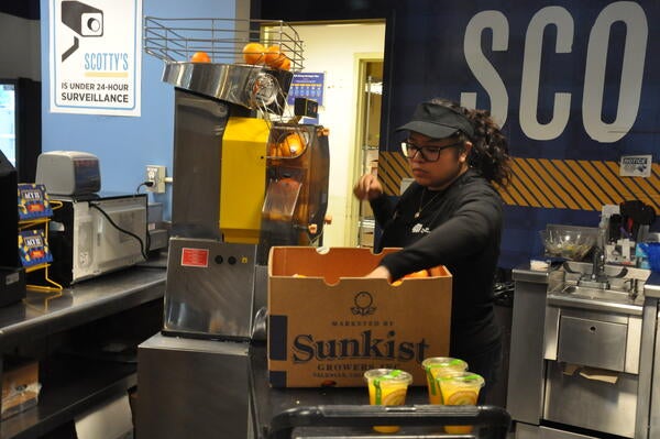 Employee making OJ at Scotty's store