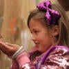 Girl child catching butterfly off of a wall