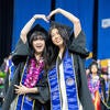 Graduates forming heart with arms