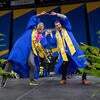 Business graduate friends celebrating on stage