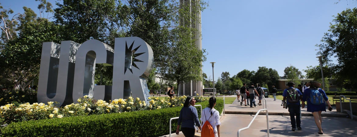 Students walking past UCR sign