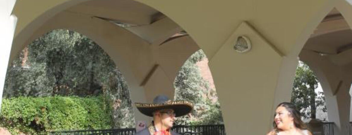 Couple poses on their wedding day under the Rivera arches at UC Riverside 
