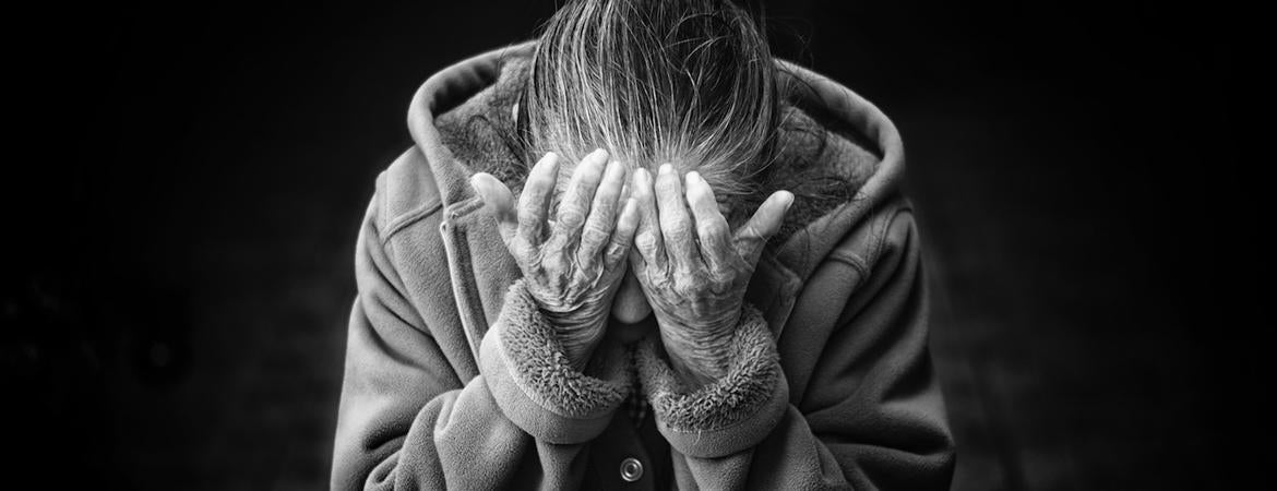 An old woman covering her face.