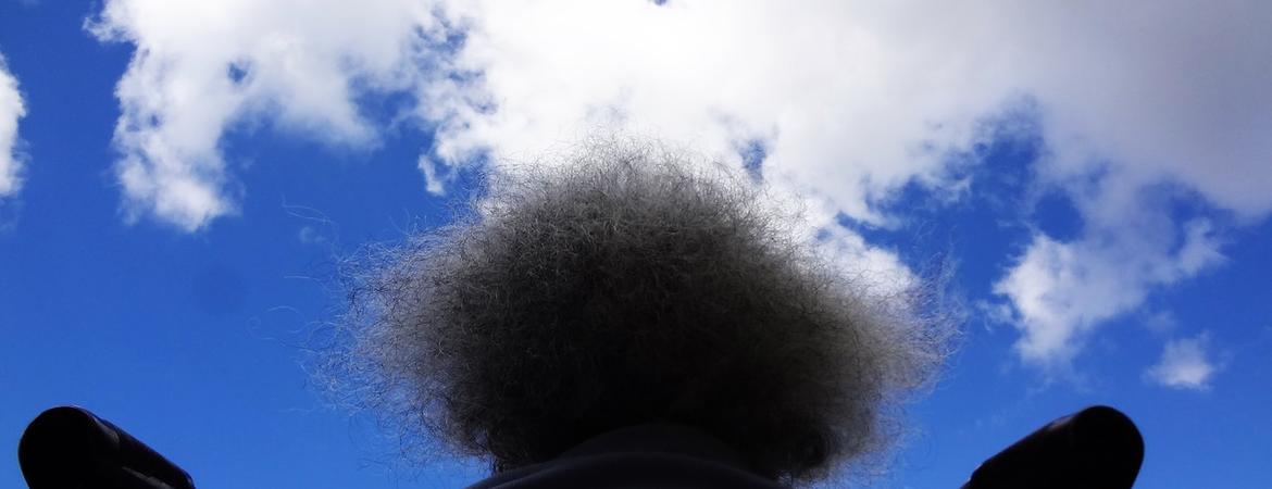 A person sitting in a wheelchair with the sky above