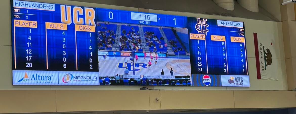 UCR Highlanders scoreboard displaying game stats and live feed in a gymnasium.