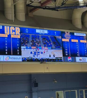 UCR Highlanders scoreboard displaying game stats and live feed in a gymnasium.