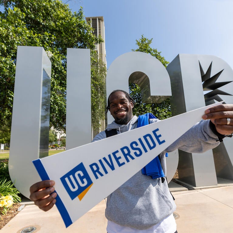 Student holding UCR pennant