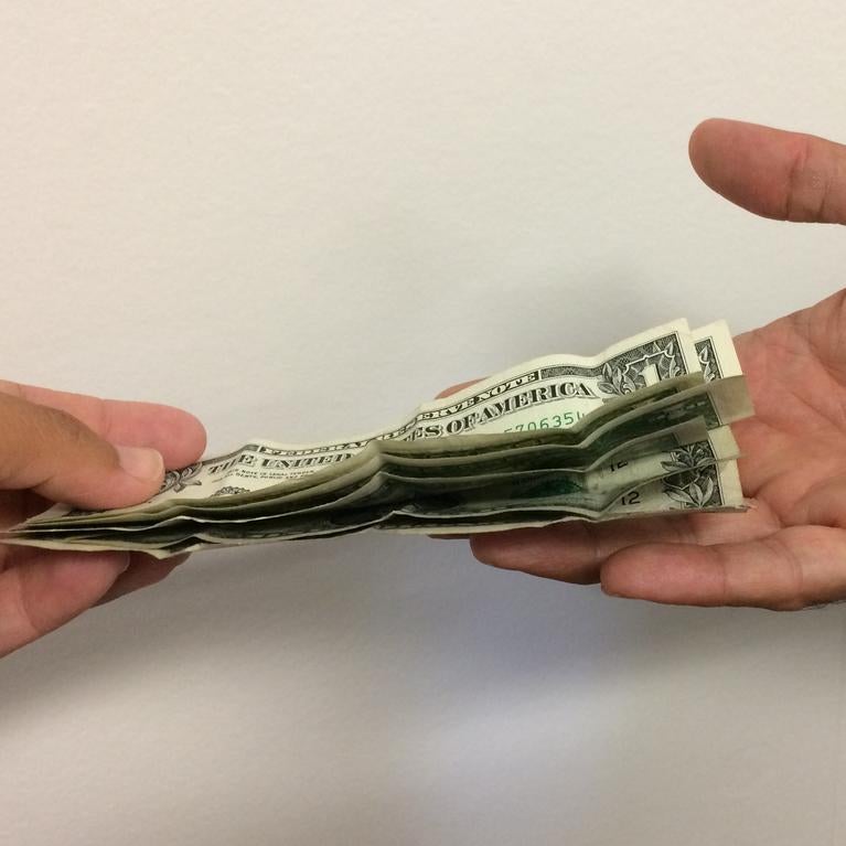 One person puts money into another person's hand