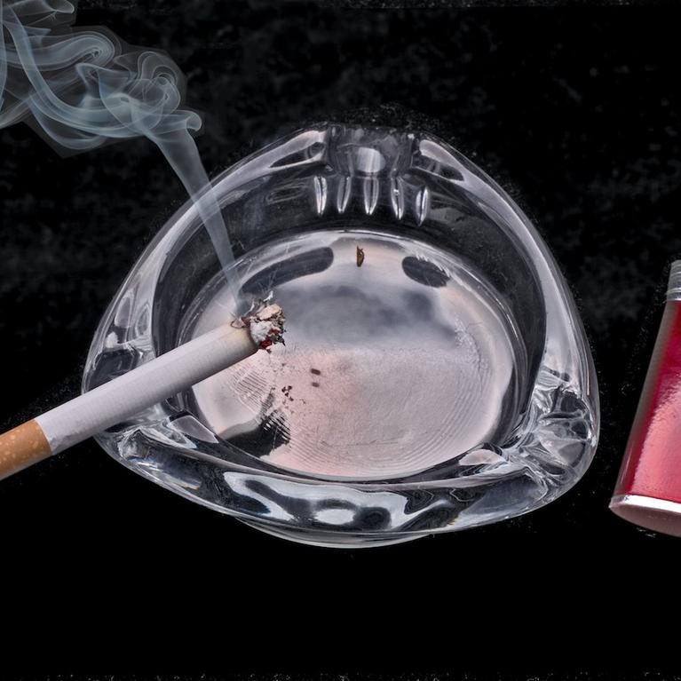 A cigarette smoking in an ashtray