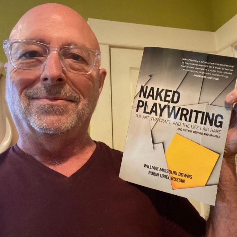 Robin Russin is pictured holding “Naked Playwriting: The Art, the Craft, and the Life Laid Bare,” a revised second edition published in January 2023. The first edition was published in 2005; this edition includes all the critical elements needed to write a play: concept, character, dialogue, and story. (UCR/Photo courtesy of Robin Uriel Russin)