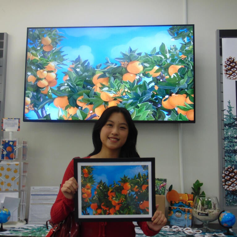 Student holding up her design