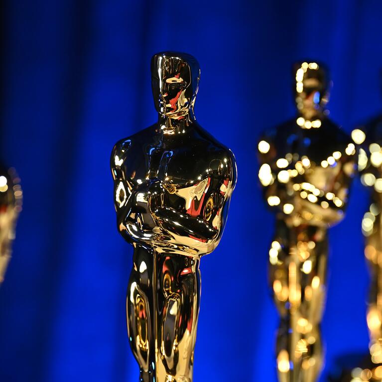 Photo of several Oscar statues in a line.