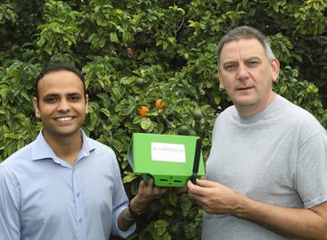 Shailendra Singh (left) and Eamonn Keogh (right) hold a FarmSense FlightSensor insect trap