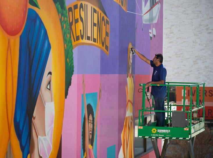 Darren Villegas works on mural