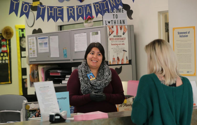 Linda Aguilera, building manager at UC Riverside’s Lothian Residence Hall, helps a student on Thursday, March 19, 2020. (UCR/Stan Lim)