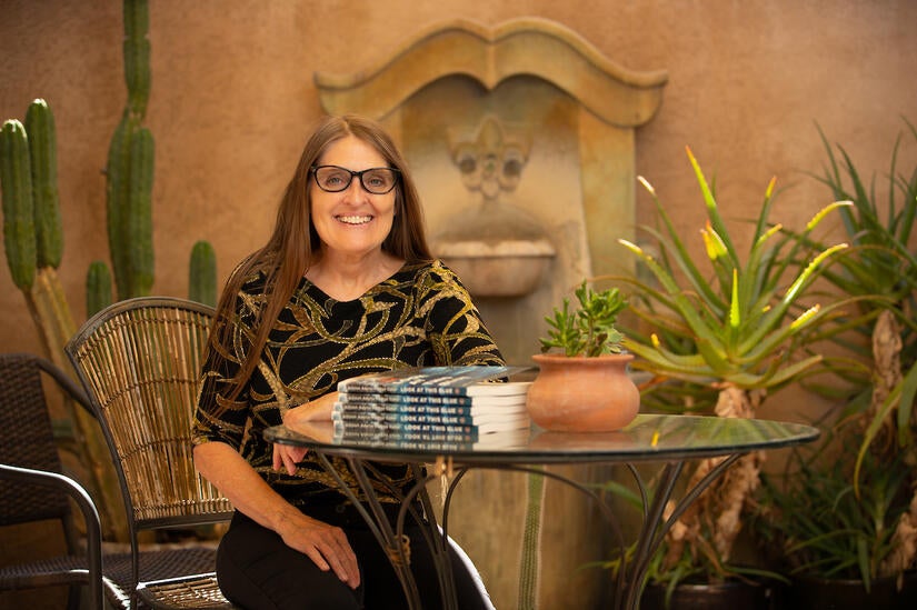 Allison Adelle Hedge Coke, a distinguished professor of creative writing at UC Riverside, with her newest book of poetry, “Look at This Blue.” The book published March 29, 2022. (UCR/Stan Lim)