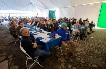 People sit in a large tent at UC Riverside's Citrus Day for the Industry